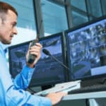 addetto controlla le immagini di una telecamera su più schermi